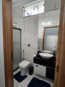 a bathroom with a toilet and a sink and a mirror at Casa Encanto in Franca +24 photos