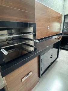 a kitchen with a black counter top and wooden cabinets at Casa Encanto in Franca
