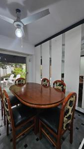 a dining room with a wooden table and chairs at Allá en el sur Canning in Ezeiza