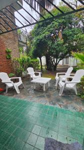 a group of white chairs sitting on a patio at Allá en el sur Canning in Ezeiza