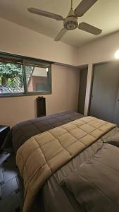 a bedroom with a large bed with a ceiling fan at Allá en el sur Canning in Ezeiza +5 photos