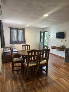 a living room with a dining room table and chairs at Cabaña El Quebrachal in Valle Hermoso