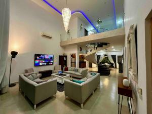 a large living room with couches and a tv at Spectacular Private House in Playa del Carmen