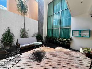 a patio with a couch and chairs in a building at Spectacular Private House in Playa del Carmen