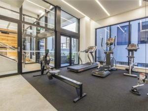 a gym with treadmills and elliptical machines and windows at Central City Prime-next to SKY in Auckland