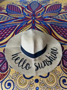 a white straw hat with the words hello summer on it at Hello Sunshine! in Cabo San Lucas