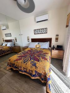 a bedroom with a bed with a colorful blanket on it at Hello Sunshine! in Cabo San Lucas