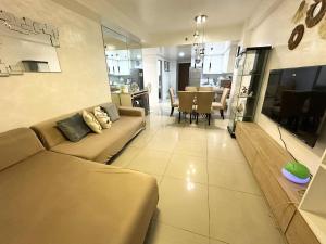 a living room with a couch and a dining room at Shell Residence 2 bedroom by Kathy in Manila