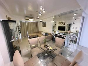 a living room with a couch and a table and chairs at Shell Residence 2 bedroom by Kathy in Manila