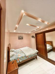 une chambre avec un lit et un miroir dans l'établissement Appartement meublé avec cuisine équipée, au bord la mer, à Guediawaye