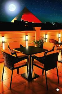 a table and chairs on a patio at night at Pyramids & SphinX Grand Hotel in Cairo