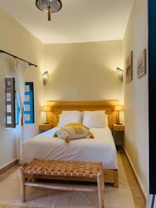 Un dormitorio con una gran cama blanca con un banco. en Riad Sultanes, en Essaouira 74 fotos más