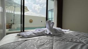 una cama en una habitación con una ventana grande en Puspa Nirwana Villa, en Kerobokan