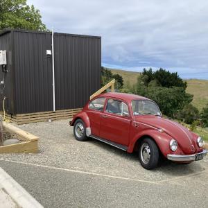 ein rotes Auto, das auf einem Parkplatz parkt in der Unterkunft Seascape on Maude in Oamaru
