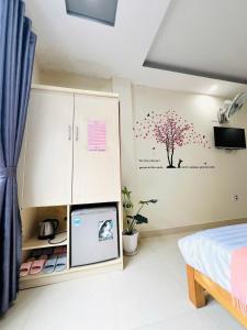 una camera da letto con un albero e fiori sul muro di Rin Bon Home a Da Lat