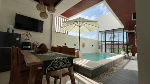 sala de estar con mesa de comedor y piscina en Puspa Nirwana Villa, en Kerobokan