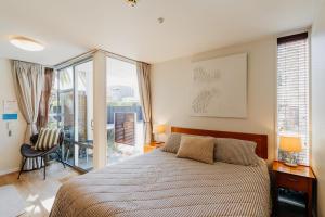 Un dormitorio con una cama y un balcón. en Sumner Bay Motel, en Christchurch