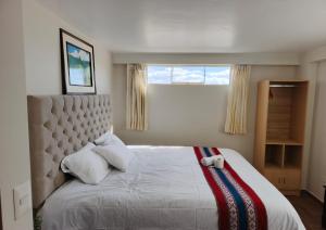 ChincherosHotel Inka House Chinchero的卧室里有一张白色的大床，床边有一扇窗户 更多32张照片