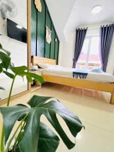 una camera da letto con un letto e una pianta in vaso di Rin Bon Home a Da Lat