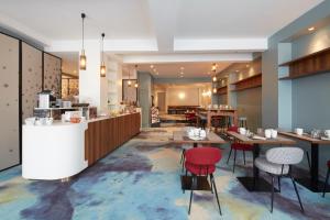Un restaurante con mesas y sillas en una sala. en Hôtel Europe and Spa, en Reims