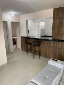 una cocina con barra y un bar con taburetes en Apto 2 qtos perto do Aeroporto, próximo ao CRER, en Goiânia