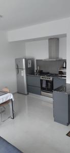 eine Küche mit Herd und Kühlschrank in der Unterkunft Maribuhomeystay in Bahía Blanca