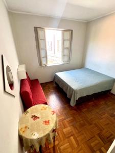 mała sypialnia z łóżkiem i stołem w obiekcie Apartamento 122 no Condomínio Quisisana w mieście Poços de Caldas +12 zdjęć