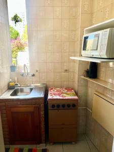 mała kuchnia ze zlewem i kuchenką w obiekcie Apartamento 122 no Condomínio Quisisana w mieście Poços de Caldas