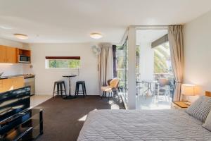 a bedroom with a bed and a kitchen and a living room at Sumner Bay Motel in Christchurch