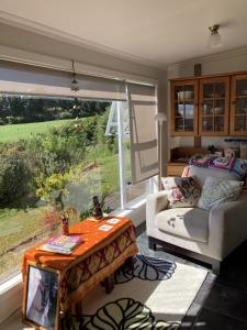 un soggiorno con un divano, un tavolo e una finestra di Klipstroom Farmstay Bed and Breakfast - Explore or relax! 