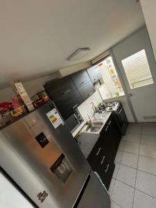 a kitchen with a stainless steel refrigerator and a sink at Departamento 3 piezas in Viña del Mar