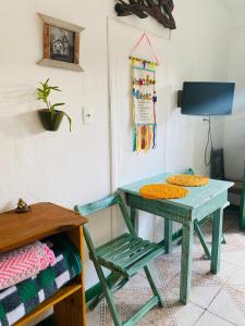 een groene tafel en een stoel in een kamer bij Casinha hibisco in Conceição da Ibitipoca