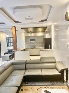 a living room with a couch and a kitchen at Apparemment meublé en face de la mer in Dakar