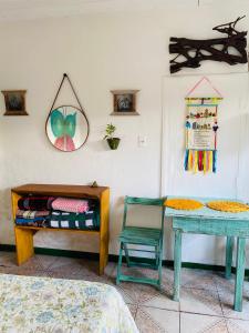 een kamer met een bed, een tafel en een stoel bij Casinha hibisco in Conceição da Ibitipoca +4 foto's