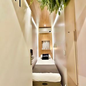 1 dormitorio pequeño con 1 cama en una habitación blanca en Capsula Hotel Sao Paulo - Paulista, en São Paulo