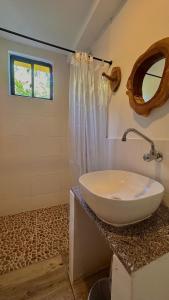 ein Badezimmer mit einem weißen Waschbecken und einem Spiegel in der Unterkunft El Regalo Finca Hostel in Salento + 26 Fotos