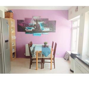 une salle à manger avec une table et des murs violets dans l'établissement The Bliss House Peaceful Retreat Close Transport Links Central London in 15mins Close to Heathrow Airport, à Harrow on the Hill