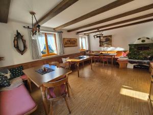 a living room with tables and chairs and a stove at Brandnerhof in Berchtesgaden