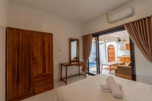 a bedroom with a bed and a door to a living room at Maharani Villa & Guesthouse Uluwatu in Uluwatu +11 photos