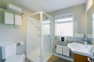 Un baño con ducha, inodoro y lavabo. en Sumner Bay Motel, en Christchurch 93 fotos más