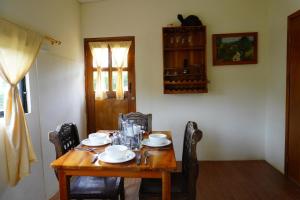 einem Holztisch mit Stühlen und Tellern darauf in der Unterkunft Shark House in Bellavista