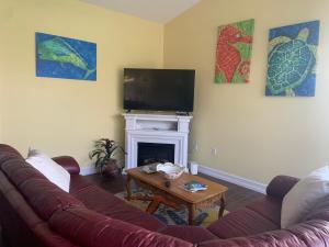 un soggiorno con un divano, una TV e un tavolo di Sunsets Waterfront Saltwater Heated Pool Retreat a Punta Gorda