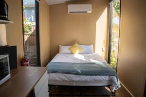 Ένα ή περισσότερα κρεβάτια σε δωμάτιο στο Cardwell by the Sea by Tiny Away