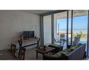 un salon avec un canapé et une table avec une télévision dans l'établissement Villa Caracol - Hello Progreso, à San Benito