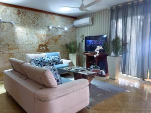 Una sala de estar con un sofá y un televisor en Villa Dylan Samana, 3Br with pool, en Santa Bárbara de Samaná