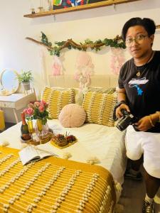 a man holding a camera standing next to a bed at Boho chic, fresh, modern apartment in Ixtapa +43 photos