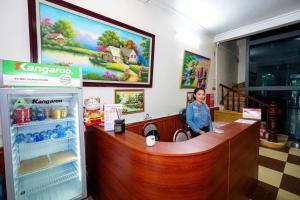 eine Frau steht an einer Theke in einem Restaurant in der Unterkunft Hà Thành Motel Bắc Ninh in Bắc Ninh