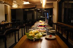 Una mesa larga con platos de comida encima. en Vanlong garden, en Kon Rung (1)