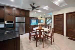 マラッカにあるLuxury Villa Hening Sari, Umbai Melaka - Smarthomeのキッチンにテーブルと椅子がある
