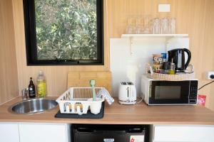 a kitchen counter with a sink and a microwave at Bush by the Bay by Tiny Away in River Heads